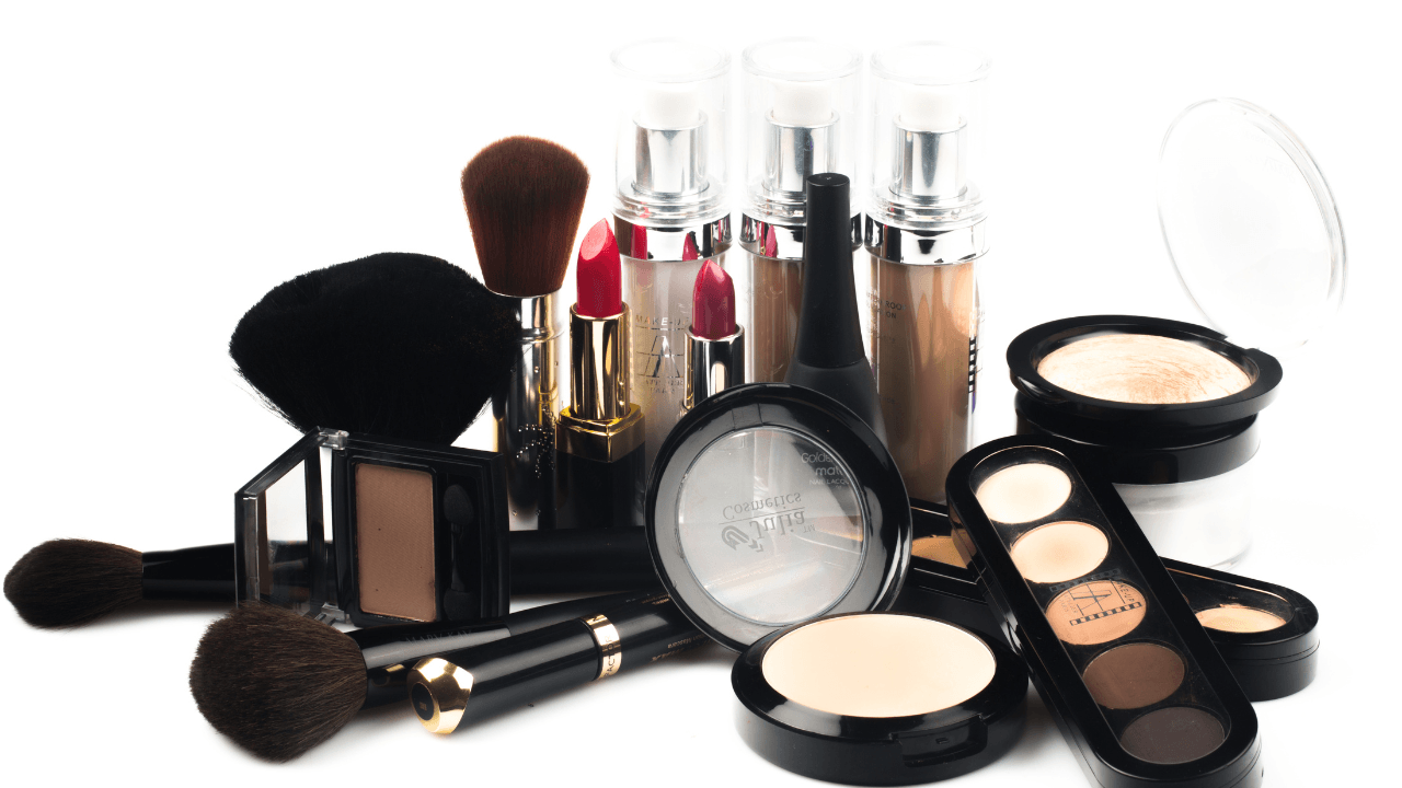 Foundation, powder, brushes, and palette arranged on white.