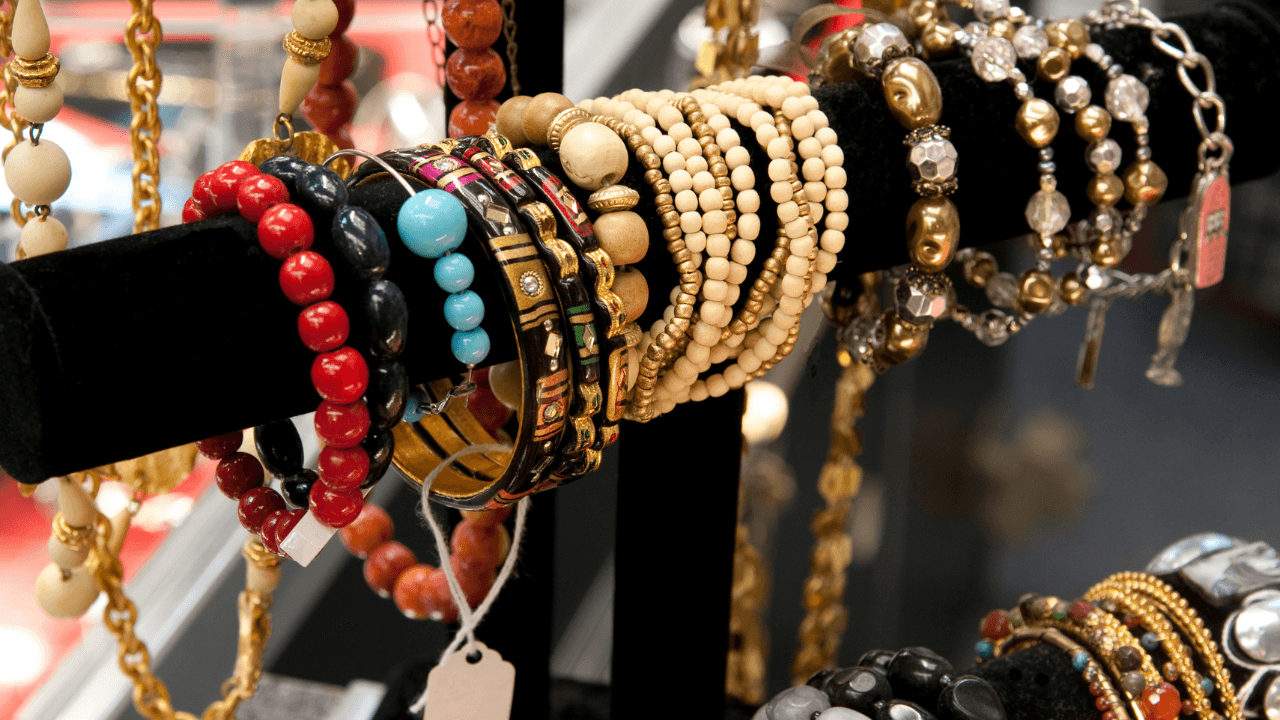 A live-sale stack of colorful beaded bracelets on a display bar.