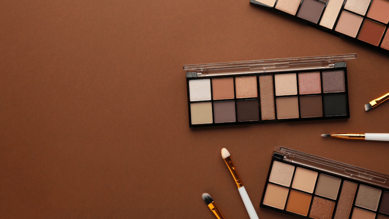 Neutral eyeshadow palettes and brushes on brown.